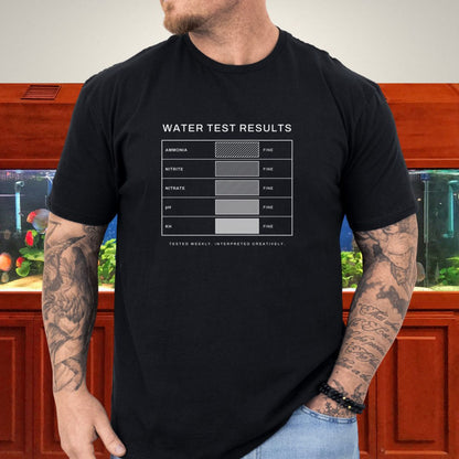 Line-art water test comparison card design (ammonia, nitrite, nitrate, pH, KH) on a dark heather unisex t-shirt